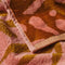 up close of orange and pink abstract palm tree and sun design woven towel