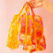 model holding set of three orange retro floral packing pouches