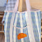 blue and lavender plaid recycled plastic tote with ribbon detail and crescent applique