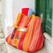 orange, yellow, and pink vertical stripe recycled plastic tote with ribbon detail and lemon applique on a step
