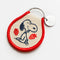 side view of cream and red patch keychain with snoopy surrounded by strawberries