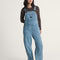 model wearing stonewash relaxed fit overalls with multiple pockets and 'carpenter' type style
