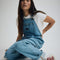 model wearing stonewash relaxed fit overalls with multiple pockets and 'carpenter' type style