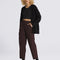 model wearing black relaxed cardigan with eyelash texture and brown pants