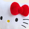 up close of hello kitty wearing blue overalls and yellow top with her iconic red bow warmie plush