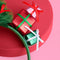 up close of green tulle christmas tree with colorful bows, gold star and stacked christmas presents