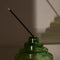 side view of green stacked glass incense holder with an incense inside on a table