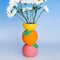 Stacked citrus vase with white daisies inside