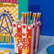 Red and white popcorn bag shaped vase with pencils inside
