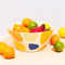 cream bowl with colorful pebble design with fruit and veggies inside