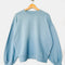 light blue relaxed fit sweatshirt on a hanger