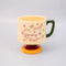 cream short ceramic mug with pink cursive 'in my growing season' with green handle and pink and yellow pedestal 