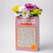 side view of pink word search puzzle book shaped ceramic vase with flowers inside