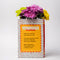 back view of pink word search puzzle book shaped ceramic vase with flowers inside