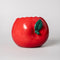 front view of apple ceramic pencil cup laying on its side with 'bite' taken out of the top with 'easy does it' fruit sticker on the side