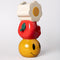 side view of stacked vase with white flower, an apple on it's side and smiley face
