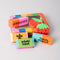 top view of set of 6 colorful erasers in a tin container with a window in the front