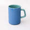 back view of blue ceramic mug with teal handle and interior
