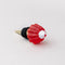 top view of gold brass wine stopper with red jello mold topper and black rubber stopper