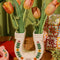 cream horseshoe ceramic vase with colorful flower trim and 'best of luck' stamp in the center with pink roses inside