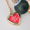 fidget keychain with gold heart photo frame, enamel orange juice charm, and 8-ball de-stress ball