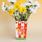 ceramic red stripe 'fresh popcorn' shaped vase with scalloped top with yellow flowers inside