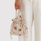 model carrying cream drawstring bag with abstract floral print