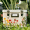 closed cream metal seed box with floral and butterfly print on the bottom and three interior compartments