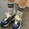 model wearing heather grey crew socks with double black stripes at the top
