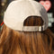 back view of cream dad hat with red bill and embroidered snoopy and strawberry print