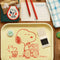 yellow school lunch tray with snoopy and woodstock sharing a snack on a table