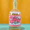 glass bottle with cream tipped matches and red flower stamp design on the bottle