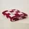 folded light pink and burgundy checkered blanket