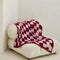 light pink and burgundy checkered blanket on a chair