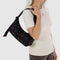 model carrying black small cargo bag with two front patch pockets and red painted wildflower print