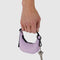 model holding dusty pink mini crescent bag charm with key hanging from it