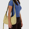 model carrying straw recycled leather medium crescent bag with matching adjustable strap and zipper trim