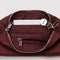 interior of nylon mahogany pochette bag with smiley charm and adjustable shoulder strap