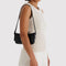 model carrying black recycled leather pochette bag