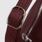 silver adjustable strap buckle of mahogany recycled leather shoulder bag with silver charm clasp