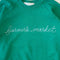 green sweatshirt with white chainstitch farmer's market across the front