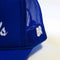 side view of royal blue trucker hat with white 'HOTEL du BEST REGARDS' across the front