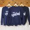 navy sweatshirt with white 'LOST IN... GOOD BOOK' across the front hanging on a hanger