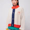 model wearing cream knit cardigan with yellow sleeve cuffs, coral trim and navy button front with embroidered couple on bust