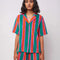 model wearing green, orange and pink vertical stripe terry cloth button front top and matching shorts