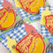 packaged red pin with gold lettering 'EMOTIONAL SUPPORT DOG' and hot dog graphic