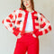 model wearing cropped red, pink and white gingham cardigan with all over embroidered ant print