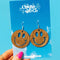 model holding wooden smiley face dangle earrings