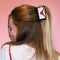 model wearing white 'love' letter' hair claw sealed with a red heart