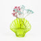 lime green glass seashell vase with dainty flowers inside
